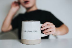 A mindfulness reminder to see more positivity and see the good in a situation written on a mug